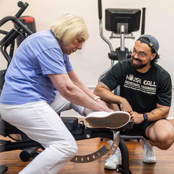 woman working out at apartment gym with trainer