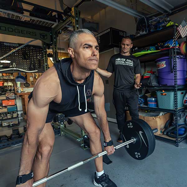 Man working out with personal trainer in his Pittsburgh garage